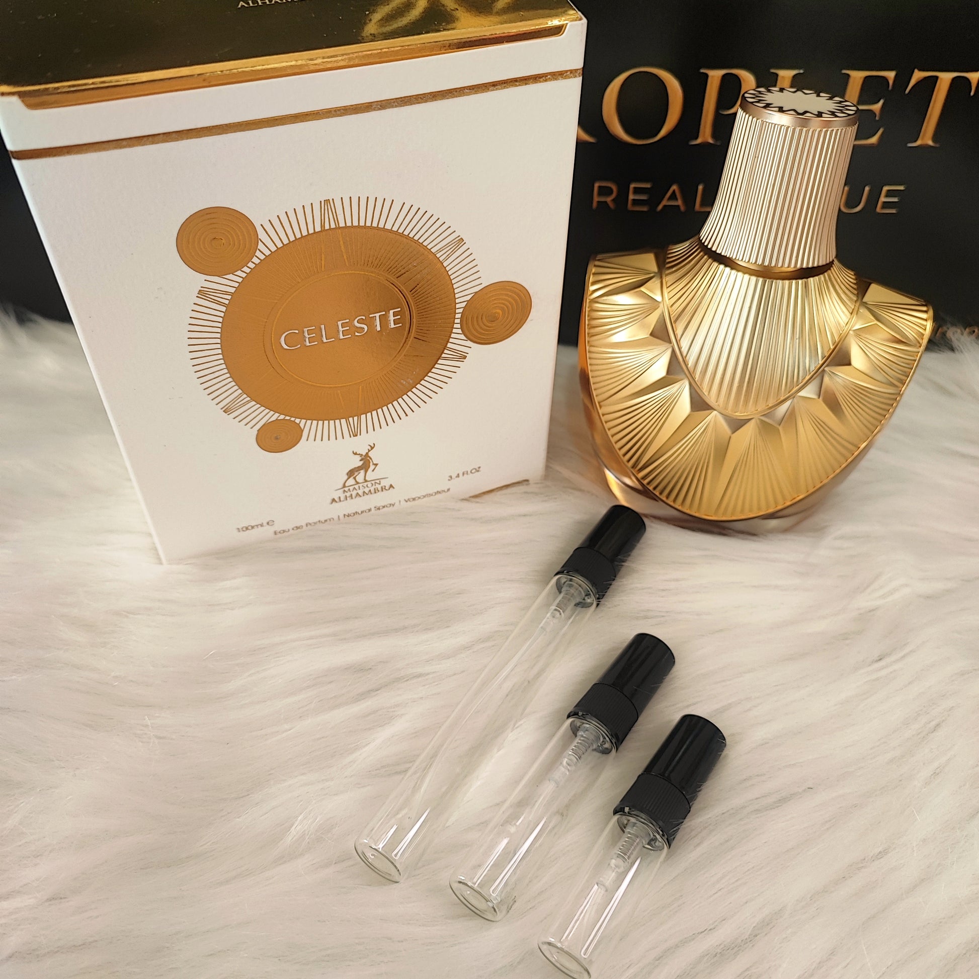 Celeste by Maison Alhambra decant vials with original bottle and box on white fur